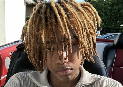 RIch Amari looking extremely serious in front of a row of cars